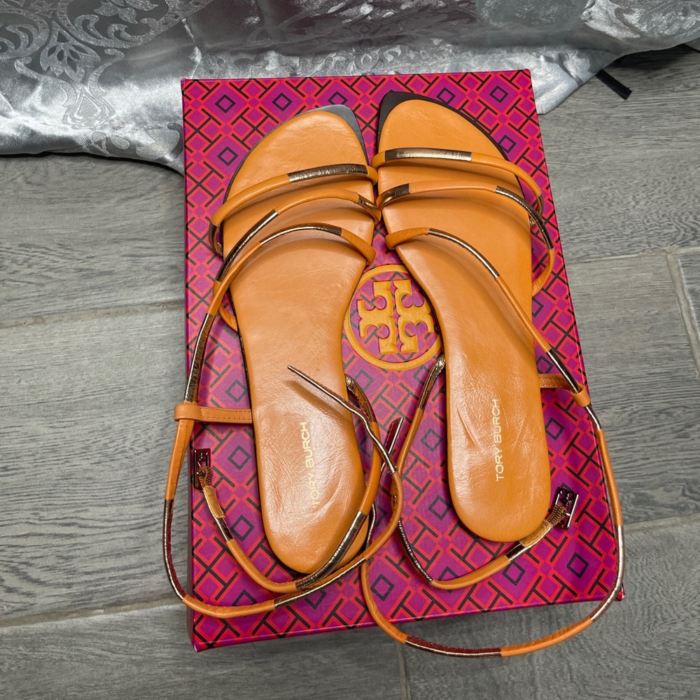 Tory Burch split mignon strappy flat sandal with gold accents.
